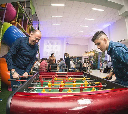 Adultos jogando pebolim durante uma festa