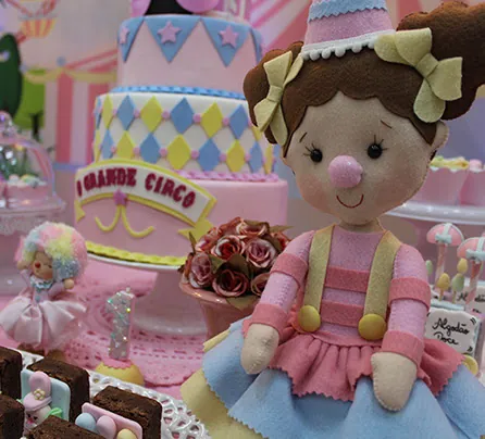 Detalhe de decoração temática com bolo cenográfico e boneca de feltro
